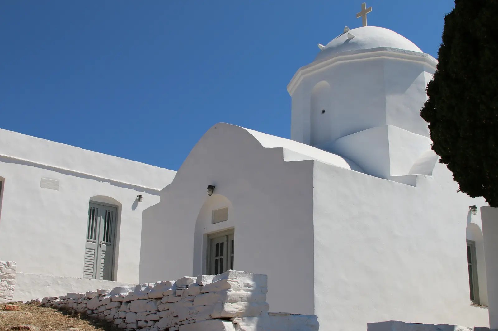 The whitewashed dome of the Agios Andreas church on Sifnos against a blue sky