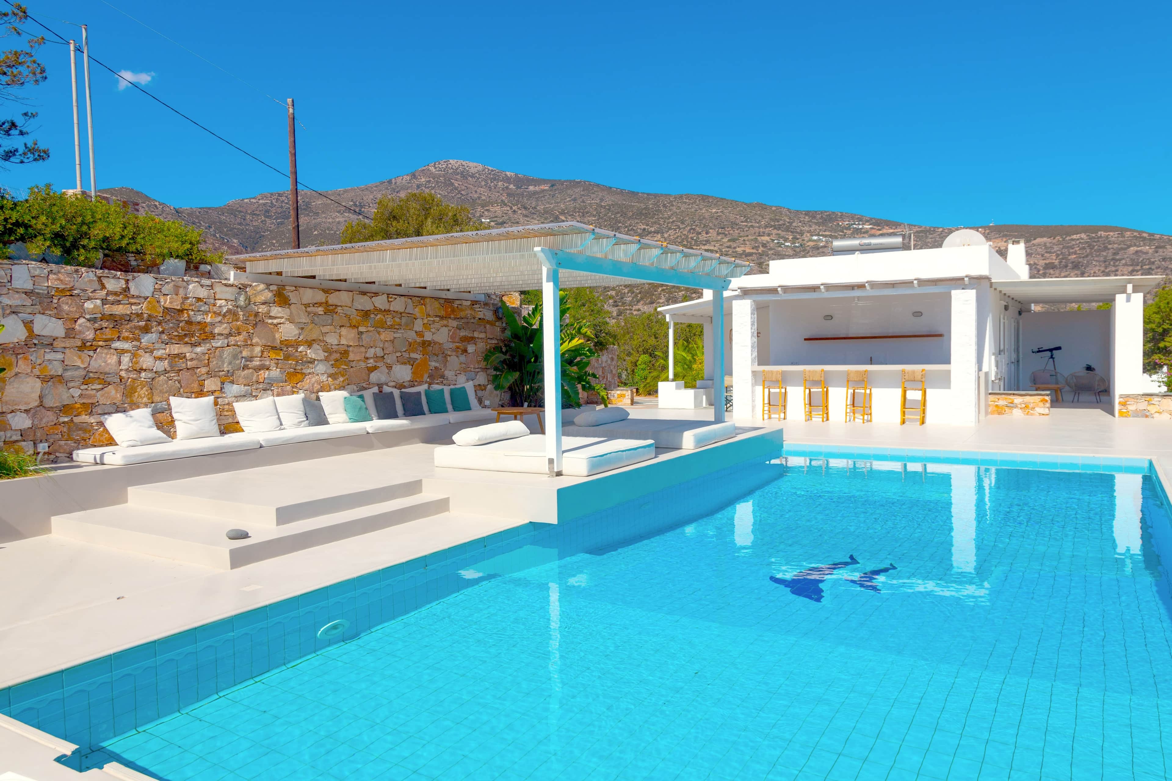 The pool, its shaded daybeds and the pool bar beyond