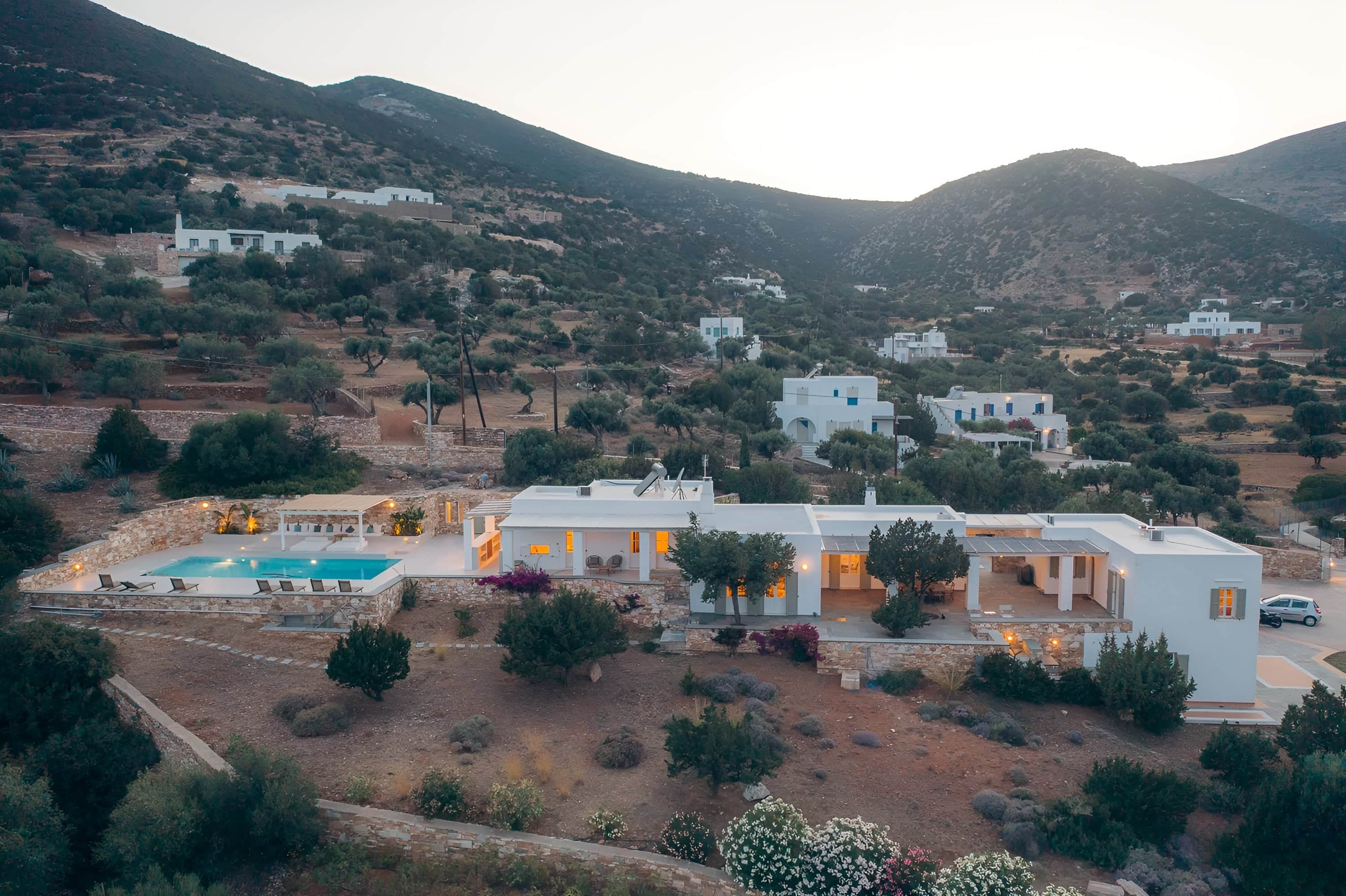 The villa and its pool from the air, the hillside behind