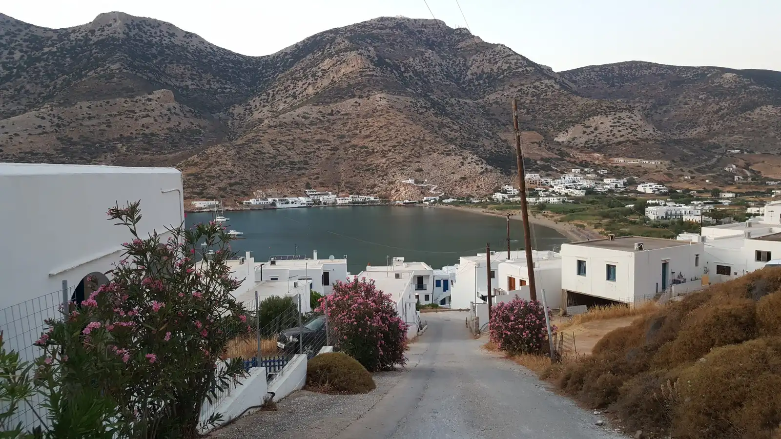 The village road winding down to the bay and ferry port of Kamares, Sifnos, where most hire cars are collected