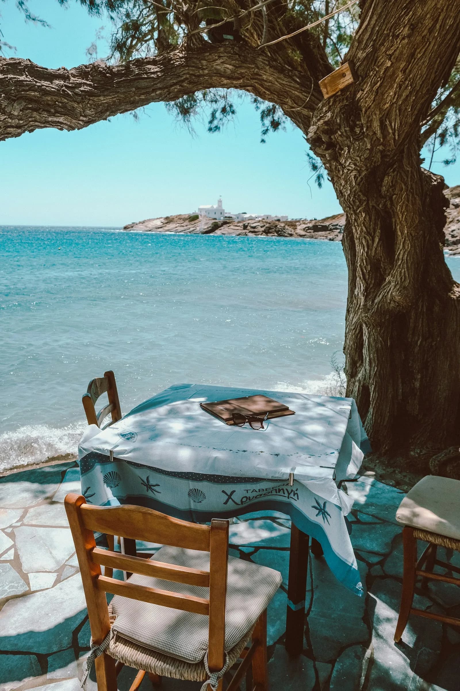 A taverna table set under vines on Sifnos